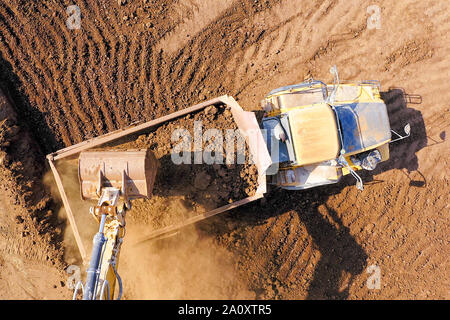 Bagger laden Boden auf einer Artikulierten hauler Truck, Top-down-Antenne Stockfoto