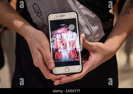 Hände von eine Demonstrantin ein Smartphone während der Demonstration Halten. Ein weiteres Wochenende, Demonstranten einrichten Barrikade auf dem Feuer und brannte eine chinesische Flagge und Polizei Pfefferspray zu erneuten Auseinandersetzungen über Missstände, die durch die anti-Demonstranten abgefeuert. Stockfoto