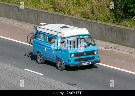 1984 80s blau weiß VW Volkswagen Caravelle 78Ps; UK Fahrzeugverkehr, Transport, Touring Caravans und Reisemobile, Wohnmobil auf britischen Straßen, Wohnmobil-Freizeitfahrzeug, Familienurlaub, Caravanette-Urlaub, Caravan-Urlaub, Van-Umbauten, autohome, Leben auf der Straße Limousinen, nach Süden auf der Autobahn 3 Lane M6. Stockfoto