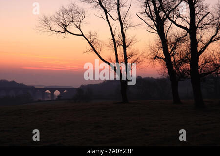 Sonnenaufgang über dem Viadukt der Vale Eisenbahnlinie, Porthkerry, Barry, South Wales, Großbritannien Stockfoto