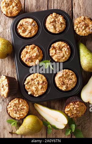 Frisch gebackene Birnen Muffins mit Zimt und Walnüsse in einer Auflaufform close-up auf den Tisch. Vertikal oben Ansicht von oben Stockfoto