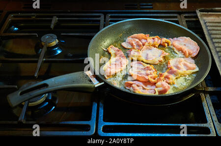 Speckscheiben von Speck in einer großen Pfanne antihaftbeschichtet tefllon beschichteten Pfanne auf dem Gasherd Stockfoto