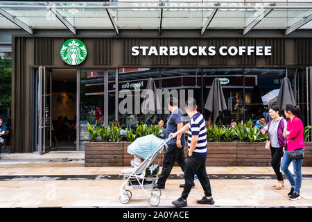 Fußgänger vorbei an einem Starbucks Stores in Shanghai. Ein amerikanischer Kaffee und Kaffeehaus Kette. Stockfoto