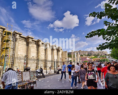 Athen/Griechenland - 17. Juli 2019: Menschen zu Fuß und Straße Verkäufer außerhalb des Hadrian's Bibliothek, archäologische Stätte in Athen, Griechenland. Stockfoto