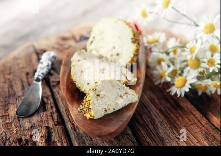 Käse belper Knolle, die in den Gewürzen roten und schwarzen Pfeffer und Kräutern der Provence. Kleine hausgemachte Kugeln von Käse Belper. Delikatesse runde kleine Käse mit Schwarz Stockfoto