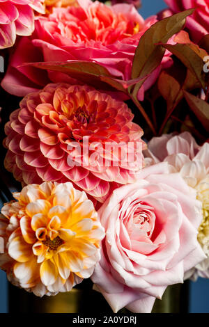 Florale Komposition von Dahlia Blumen, Rosen und Blätter im Herbst. Arty, leuchtend rot und rosa Blumenstrauß Stockfoto