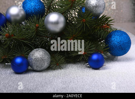Dekorativer Hintergrund mit Tannenzweigen und rote Kugeln auf das Silber. Christmas Card Urlaub Konzept Stockfoto
