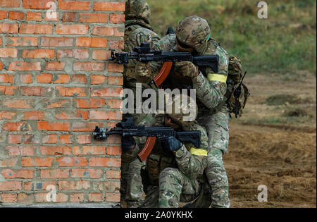 Ukrainische Soldaten von den besonderen Polizei eine Ecke bei einem Brand team Bewegung und Zimmer clearing Demonstration als Teil der Schnellen Trident 2019, Sept. 20, 2019, in der Nähe der Yavoriv, Ukraine durchqueren. RT19 ist eine jährliche, multinationale Übung, die ca. 3.700 Mitarbeiter aus 14 Nationen, die Unterstützung gemeinsamer kombinierte Interoperabilität zwischen den Partnerländern der Streitkräfte der Ukraine und den Vereinigten Staaten sowie im Rahmen der Partnerschaft für den Frieden der Nationen und NATO-Verbündeten. (U.S. Armee Foto von Pvt. Joanna Gaona Gomez) Stockfoto