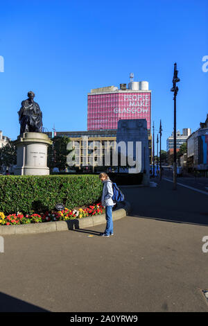 Ein Besucher hält einen Hinweis auf den Boden auf dem George Square, Glasgow zu erwägen. Stockfoto