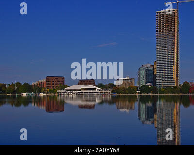 Reflexionen in einem See - Mehrfamilienhäuser und Bürogebäude in den ruhigen Gewässern von Dow's Lake, Ottawa, Ontario, Kanada nieder. Stockfoto
