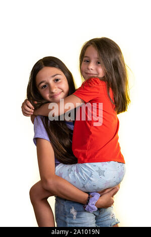 Junge jugendlich Mädchen, dass in ihren Armen und ihrem kleinen Freund glücklich mit Blick auf die Kamera, auf einem weißen Hintergrund. Stockfoto