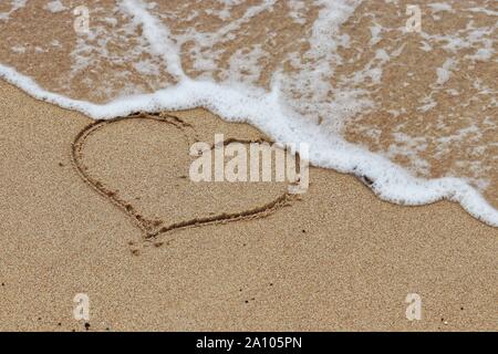 Herzform an einem Sandstrand und eingehende sea wave. Das Konzept der flüchtige Liebe, Romantik, romantische Reisen Urlaub Stockfoto