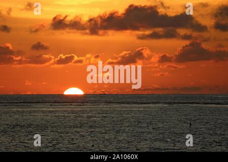 Sonnenuntergang am Strand, abends Sonne Untergang in dunklen Meer. Dramatische Himmel mit Wolken Stockfoto