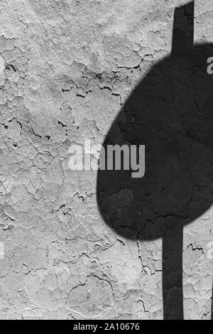 Von der Straße Wegweiser Schatten auf Grunge gerissene Wand an einem sonnigen Tag auf der Straße der Stadt Stockfoto