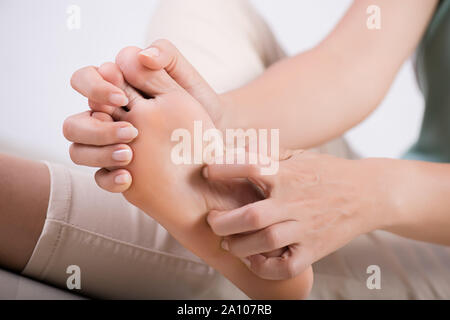 Close up Frau Fuß scratch die Krätze von Hand zu Hause. Gesundheitswesen und Medizinische Konzept. Stockfoto