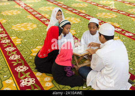 Eine Gruppe von Jungen und Mädchen studieren im Inneren Masjid Moschee, Singapur Stockfoto