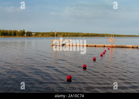 Die seebrücke und die roten bojen an einem Strand in den ländlichen Finnland. Sie können noch den Sommer auf dieser Herbstmorgen. Stockfoto