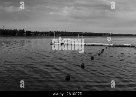 Die seebrücke und die roten bojen an einem Strand in den ländlichen Finnland. Sie können noch den Sommer auf dieser Herbstmorgen. Stockfoto