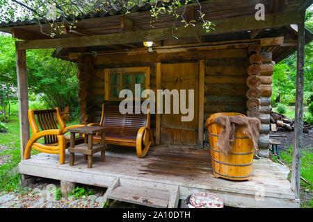 Die Veranda mit einem kleinen Badehaus auf der Veranda, von denen gibt es Bänke und eine große alte Bad. Erholung und Gesundheit in der Natur. Stockfoto