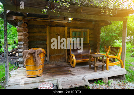 Die Veranda mit einem kleinen Badehaus auf der Veranda, von denen gibt es Bänke und eine große alte Bad. Erholung und Gesundheit in der Natur. Stockfoto