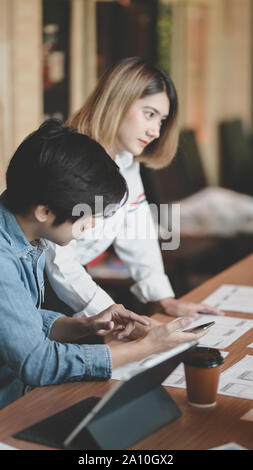 7/8-Ansicht von UI-Designer Hobeln der UX-Anwendungsentwicklung mit Teammitgliedern in modernen Arbeitsplatz Stockfoto