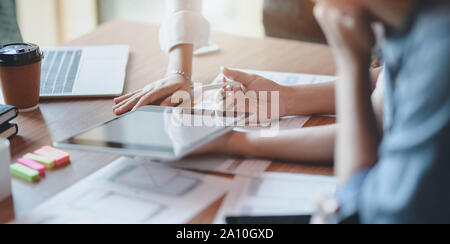 7/8-Ansicht von UI-Designer Hobeln der UX-Anwendungsentwicklung mit Teammitgliedern in modernen Arbeitsplatz Stockfoto