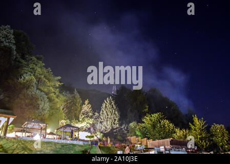Kaschmir und Jammu und Kaschmir, Indien. 22 Sep, 2019. Rauch aufsteigt, bei einem Waldbrand in Srinagar, Kashmir. Ein Großbrand versenkt die Zabarwan Hügel hier am Sonntag Abend. Berichte sagte, dass ein Brand in den Wald gestartet und die Flammen könnten aus Gupkar, die hohe Sicherheit, wo offizielle Wohnsitze der meisten Mainstream Politiker befinden, gesehen werden. Credit: Saqib Majeed/SOPA Images/ZUMA Draht/Alamy leben Nachrichten Stockfoto
