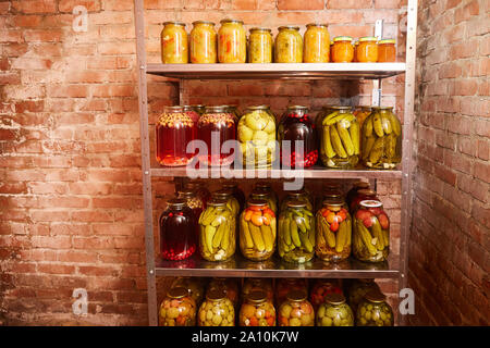 Lagerung von Obst und Gemüse für den Winter. Vitrinen mit Banken mit Leerzeichen im Haus Keller. Horizontale erschossen. Stockfoto