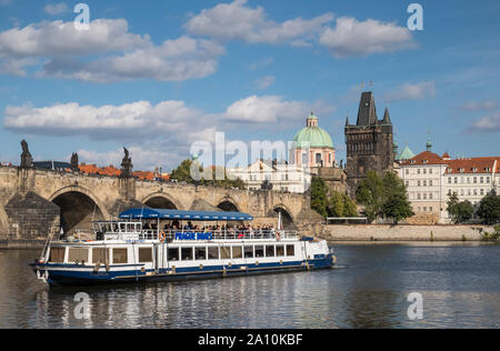 Eine touristische Fluss Bootsfahrt auf der Moldau in der Nähe von historische Karlsbrücke, Prag, Tschechische Republik Stockfoto