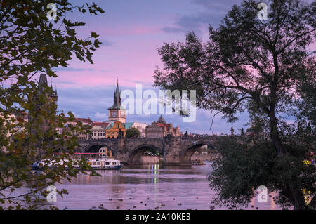 Historische Karlsbrücke und die Skyline der Stadt gegenüber der Moldau bei Sonnenuntergang, Prag, Tschechische Republik Stockfoto