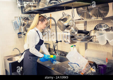 Kellnerin Geschirr in der Spüle am Ende des Arbeitstages in der professionellen Küche Stockfoto
