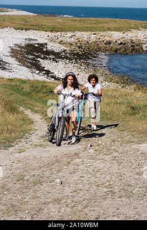 Mutter und Tochter fahren Fahrräder genießen Sie die Aussicht auf die Landschaft auf der Insel Batz Stockfoto