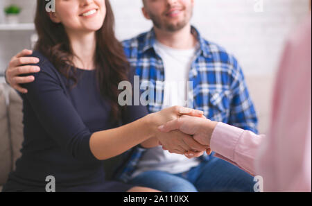 Dankbar paar Handshaking mit Spezialist bei Ratgeber Büro Stockfoto