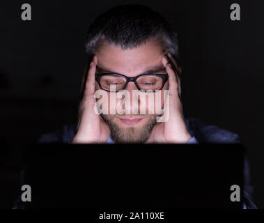 Nahaufnahme von konzentriert man analizing Informationen über Laptop Stockfoto