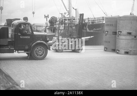 Versandkosten Guinness Bier in riesigen Metall Bierfässer (ortsbewegliche Tanks) per Lkw zu den Docks auf Schiffen durch Gabelstapler, Dublin geladen werden, Eire C. 1955 Stockfoto