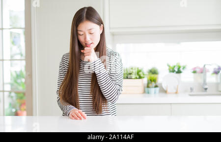 Schöne asiatische Frau mit Streifen pullover Unwohlsein und Husten als Symptom für kalte oder Bronchitis. Healthcare Konzept. Stockfoto