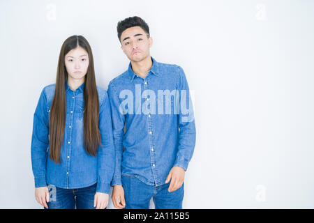 Schöne junge asiatische Paar über Weiß isoliert Hintergrund gedrückt und für Not, Sorge und schrie wütend und ängstlich. Traurigen Gesichtsausdruck. Stockfoto