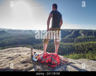 Wanderer geniessen Erfrischung. Touristen bleiben auf Rock und Bergblick genießen. Stockfoto