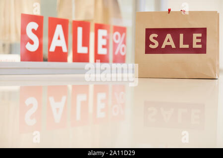 Hintergrundbild von Shopping Bag stehend gegen Fenster mit roten Verkauf Zeichen, Kopieren Raum Stockfoto