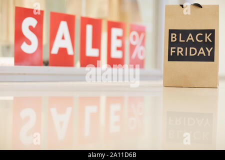 Hintergrund Bild der Schwarze Freitag Shopping Bag stehend gegen Fenster mit roten Verkauf Zeichen, Kopieren Raum Stockfoto