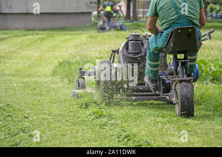 Arbeitnehmer Mähen von Gras in einem Stadtpark. Stockfoto