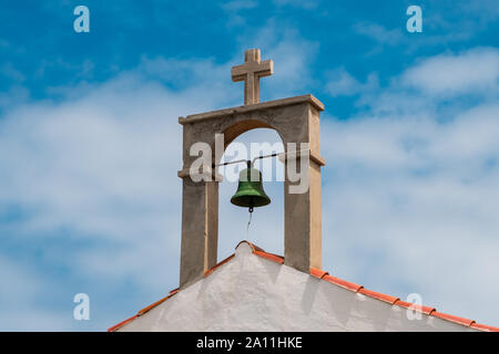Kirchenglocke und Kreuz auf ländlichen Kirche Dach Stockfoto