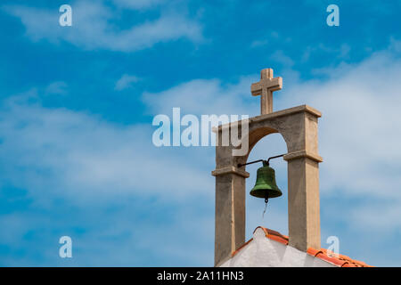 Kirchenglocke und Kreuz auf dem Dach der Kirche Stockfoto