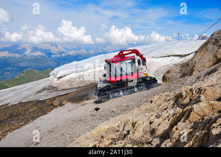 Marmolada Gletscher, Italien - 28. August 2019: PistenBully Pistenfahrzeug Maschine Parken neben dem restlichen Schnee Patch, mit einer Sonne schützen Wh abgedeckt Stockfoto