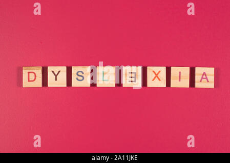 Holz- alphabet Blöcke mit Legasthenie Wort auf rosa Hintergrund. Konzept der Legasthenie das Bewusstsein und die Entwicklung des Gehirns Stockfoto