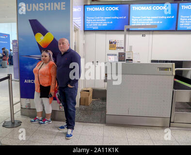 Martin Nowell und Pixie Flageul vor leeren Thomas Cook Check-in-Schalter am Flughafen Gatwick in Sussex, wie die 178-jährige tour operator Handel mit sofortiger Wirkung, nachdem man ein abschließendes Angebot ein Rettungspaket von Gläubigern zu sichern eingestellt hat. Stockfoto