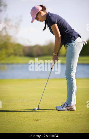 Weibliche Golf Spieler setzen auf Grün. Stockfoto