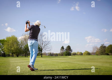 Alter Golfspieler schießen auf Grün. Stockfoto