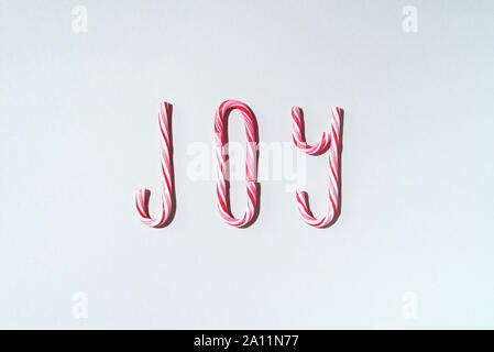 Freude Wort geschrieben mit Weihnachten candy auf grauem Hintergrund Stöcke. Ansicht von oben. Flach. Neues Jahr und Weihnachten Konzept. Stockfoto