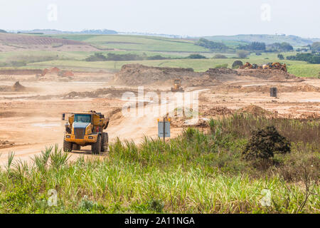 Industrielle Bau maschinen Mobilbagger Muldenkipper Kipper bin bewegt sich die Erde auf neue industrielle Eigentum Erdbau Entwicklung Plateau in countrysids Stockfoto